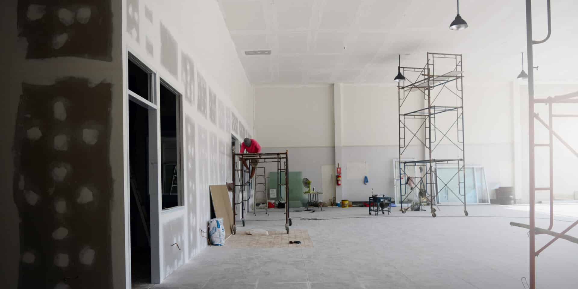 The Iron Scaffoldings On Tile Ground And The Black Lamp On The Ceiling With The Labor While Renovation The Old Office